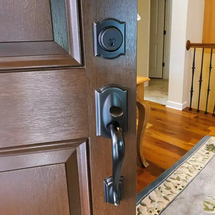 Close-up Of Interior Dark Metal Door Handle And Deadbolt Set On A Wooden Door. Close-up Of Interior Dark Metal Door Handle And Deadbolt Set On A Wooden Door.