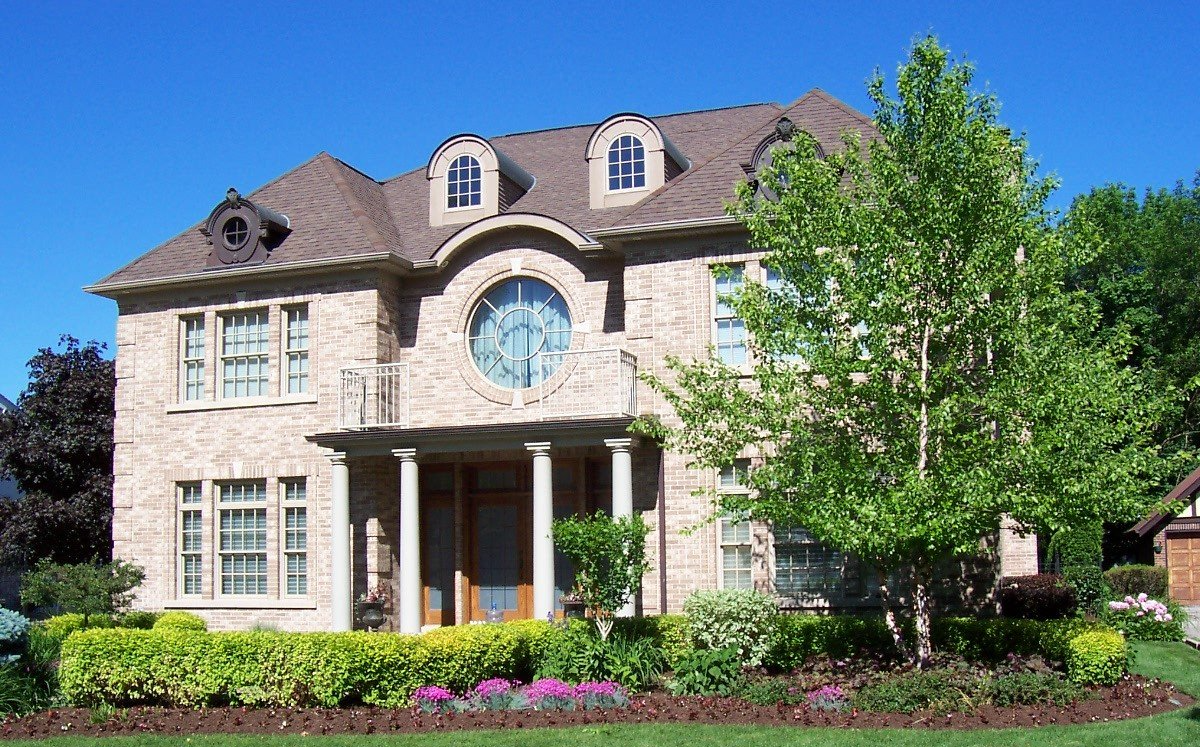 A large brick house with a clock on the top of it