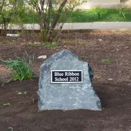 A large rock with a plaque on it that says `` blue ribbon school 2012 ''.