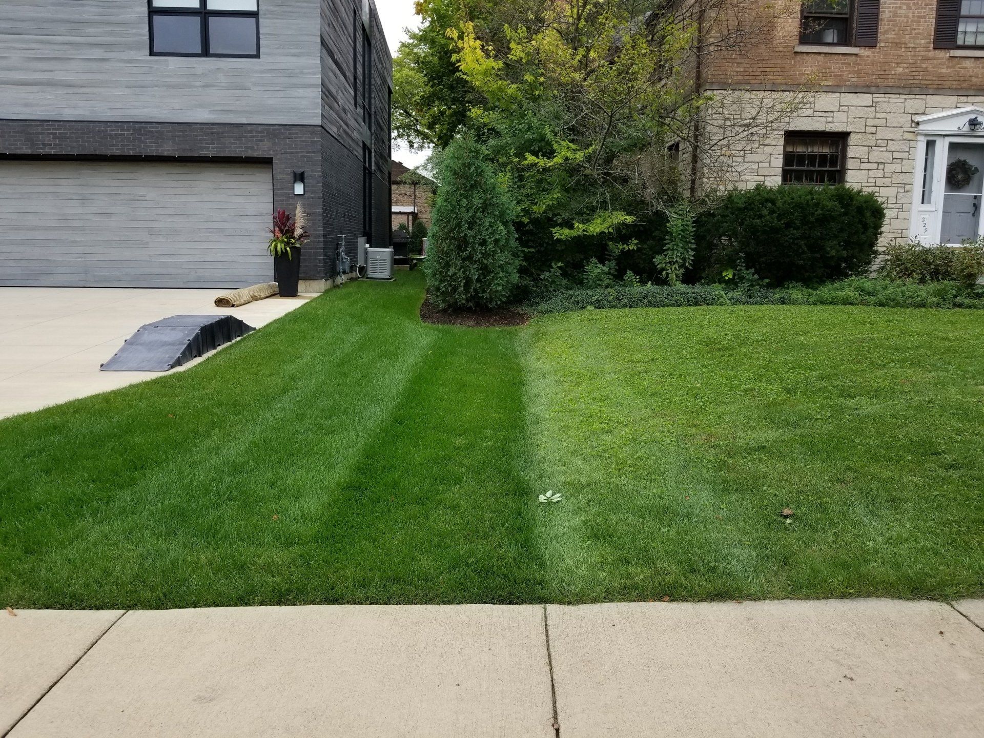 A lawn is being mowed in front of a house.
