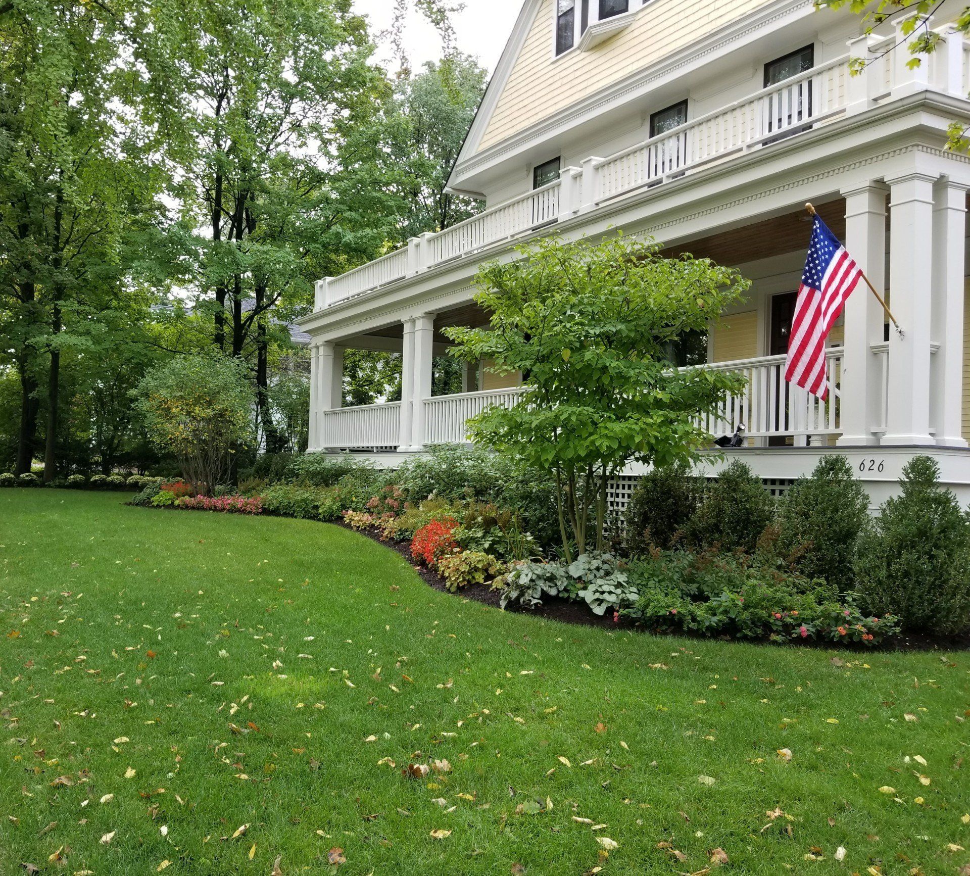 A house with a large porch and an american flag on it