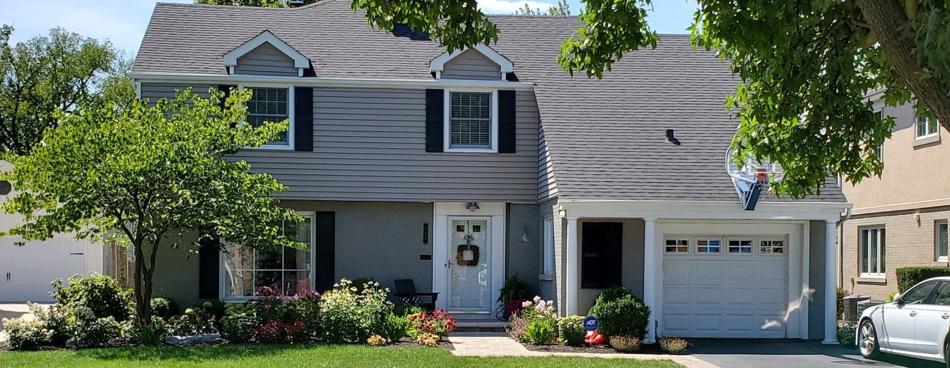 A large house with a white car parked in front of it.
