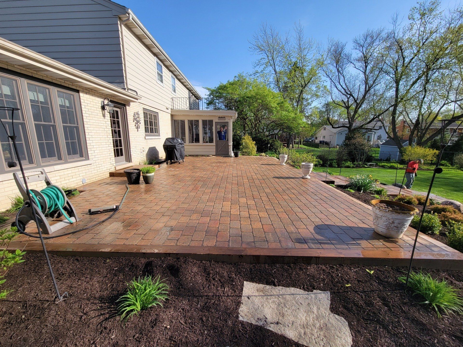 A large brick patio in front of a house.