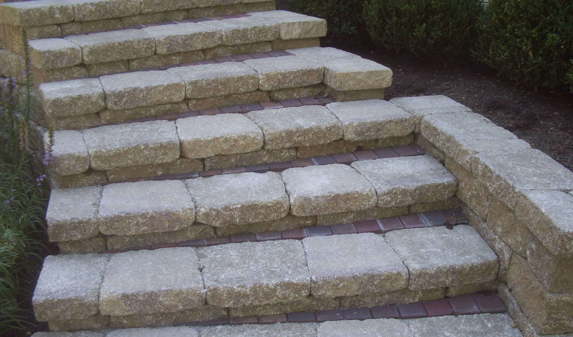A set of stone steps leading up to a brick wall