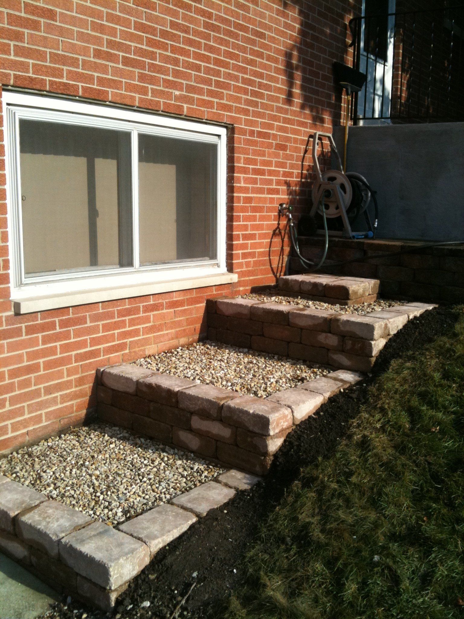 A brick building with steps leading up to a window