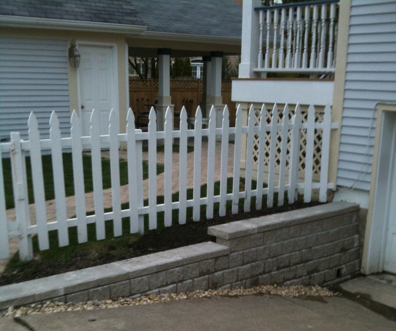 A white picket fence is in front of a house
