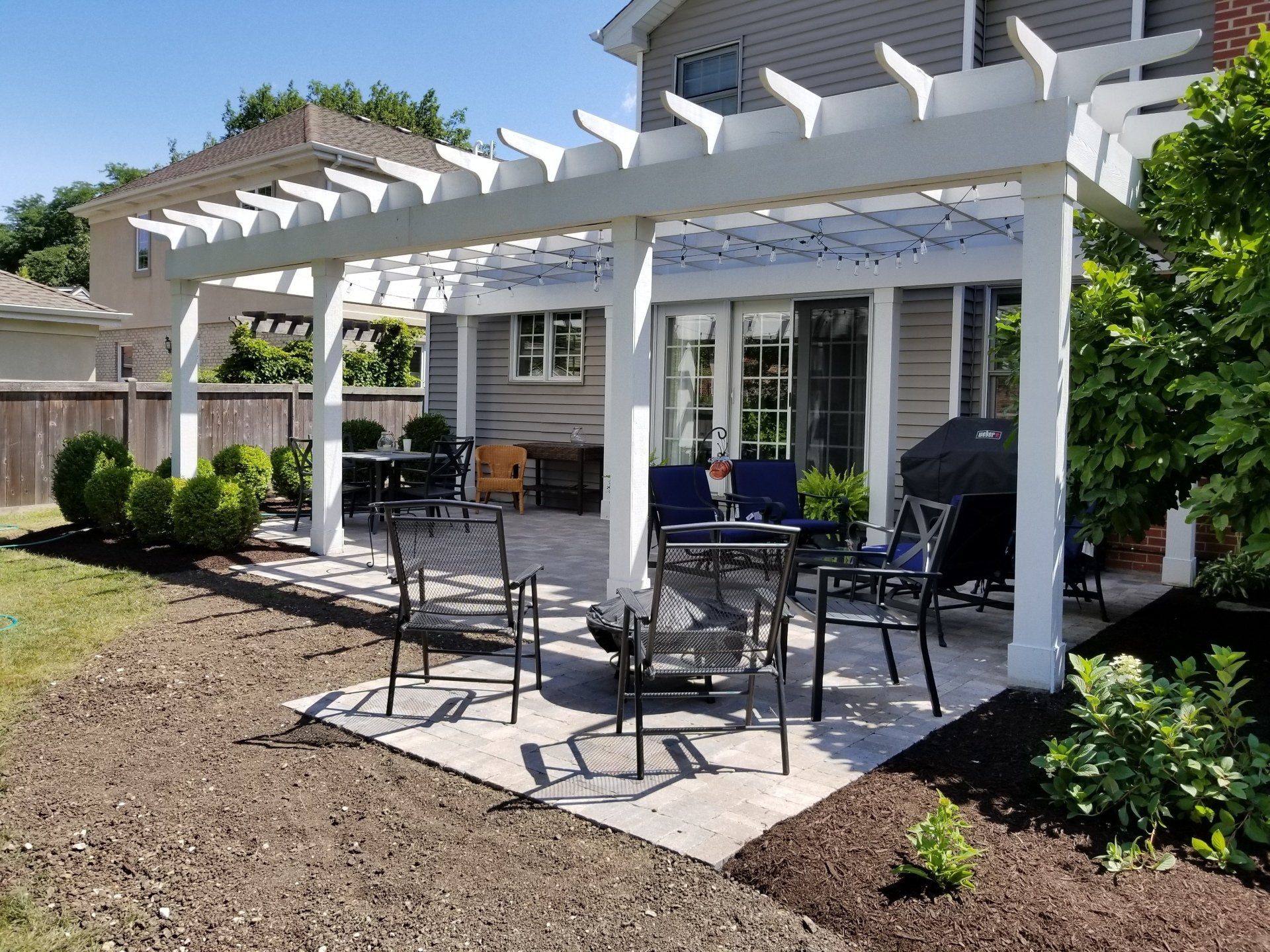 There is a pergola with a table and chairs underneath it.