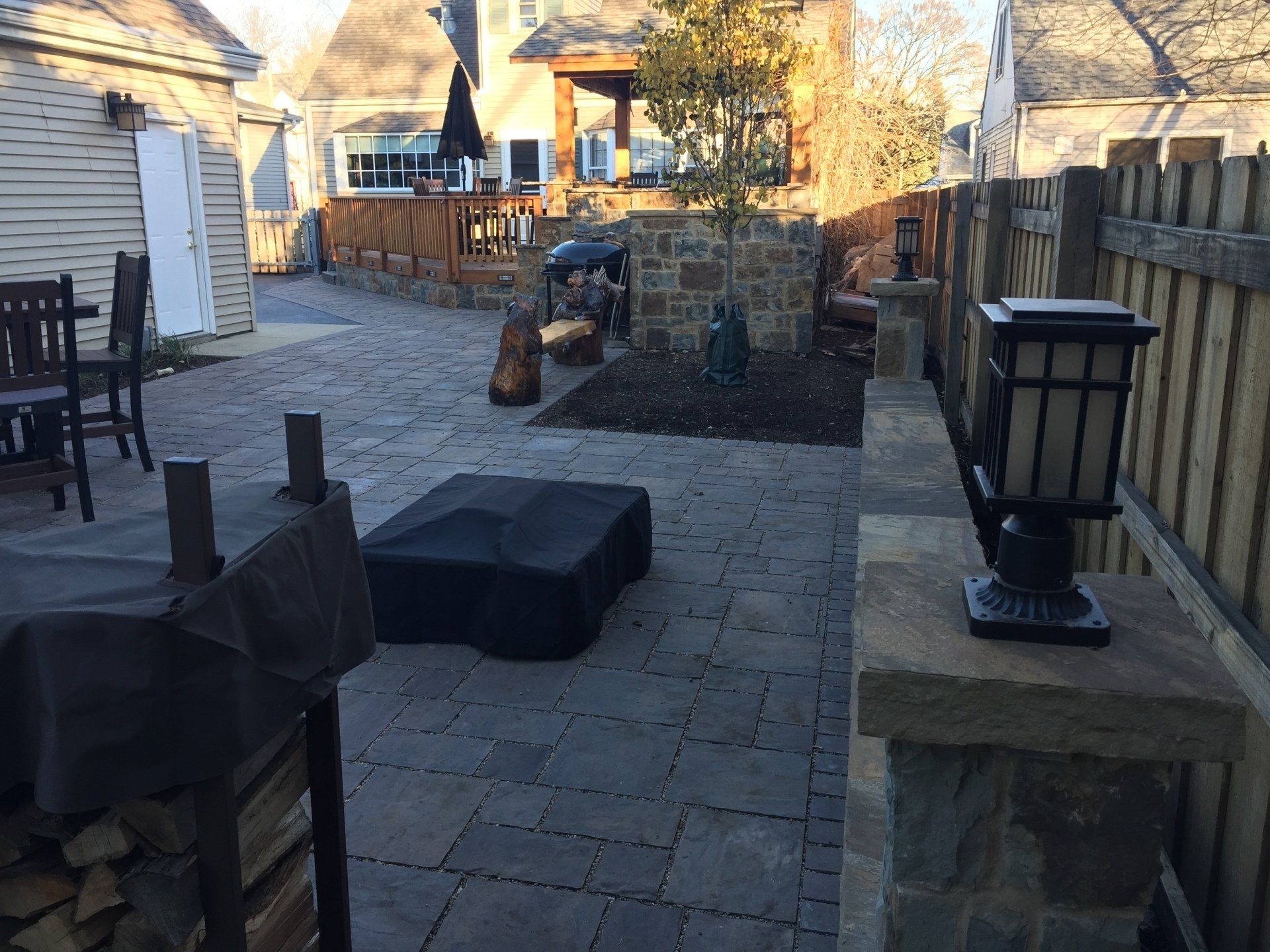 A patio with a fire pit and a wooden fence