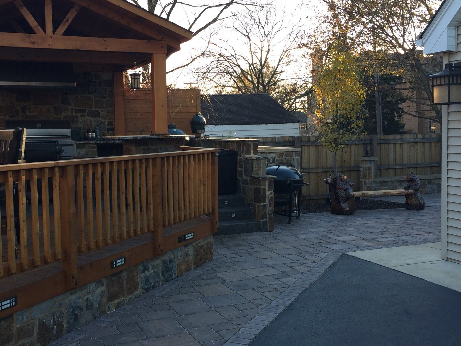A patio with a wooden deck and a grill