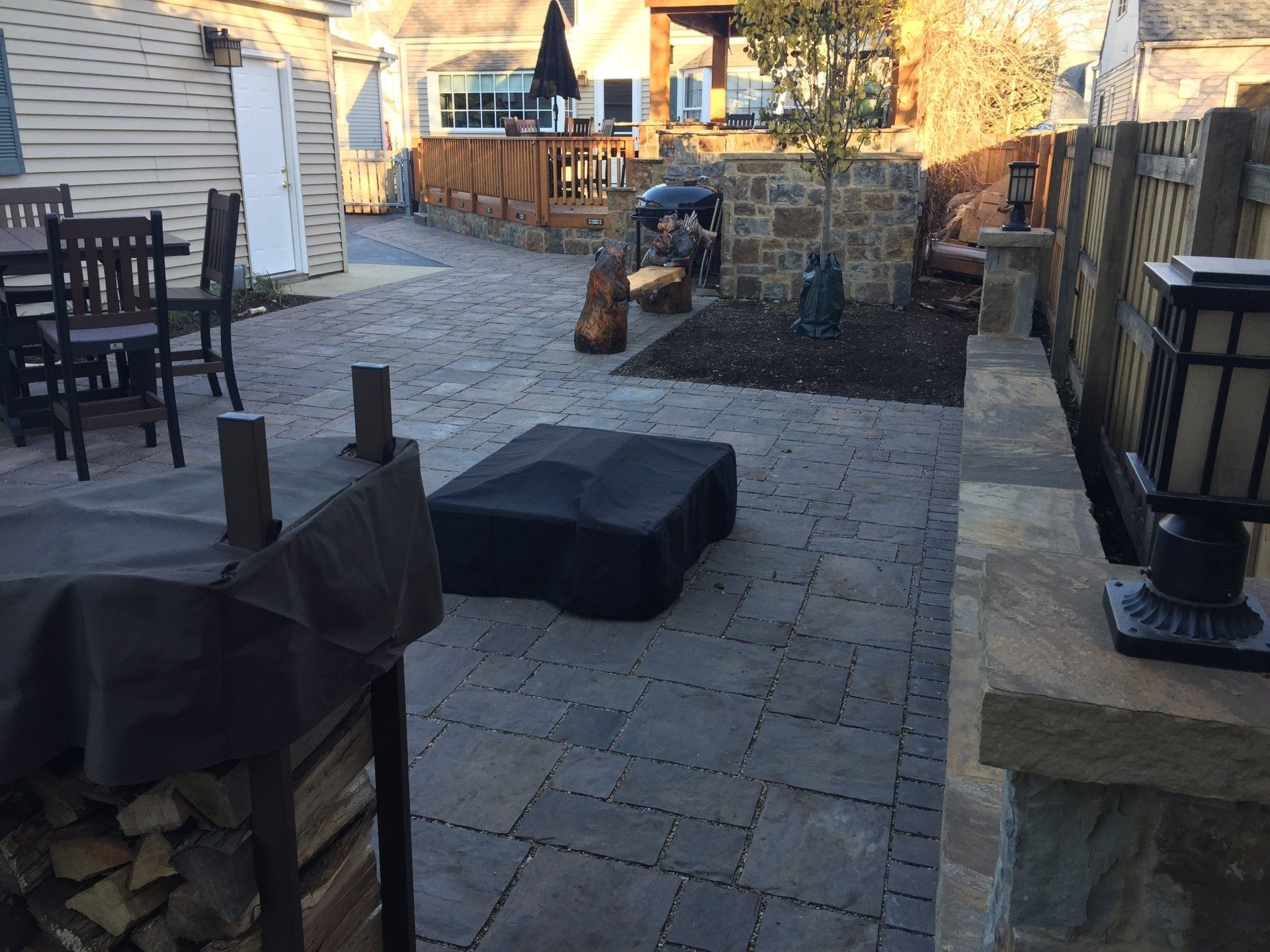 A patio with a table and chairs and a fire pit