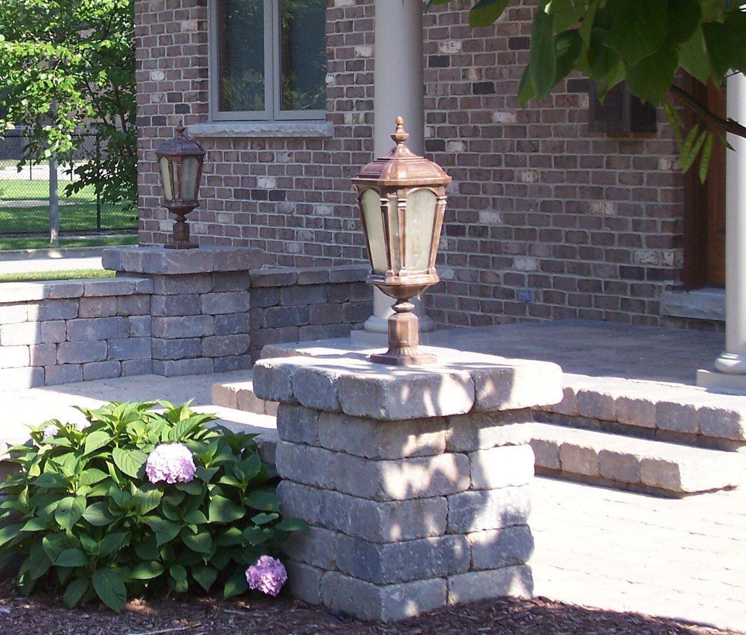 A lamp post in front of a brick house