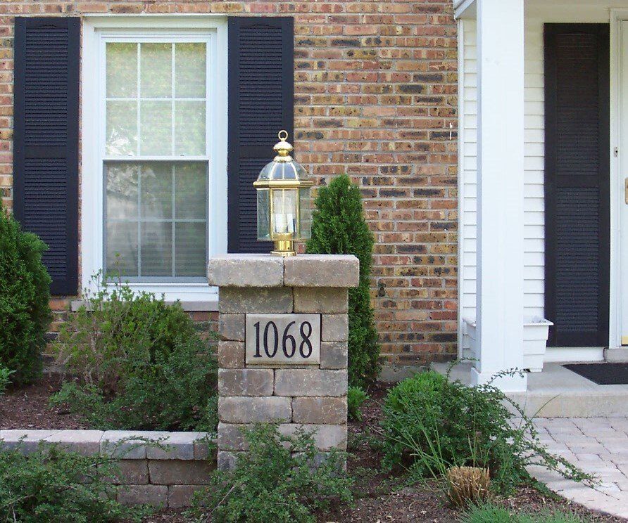 A brick house with the address 1068 on a stone pillar