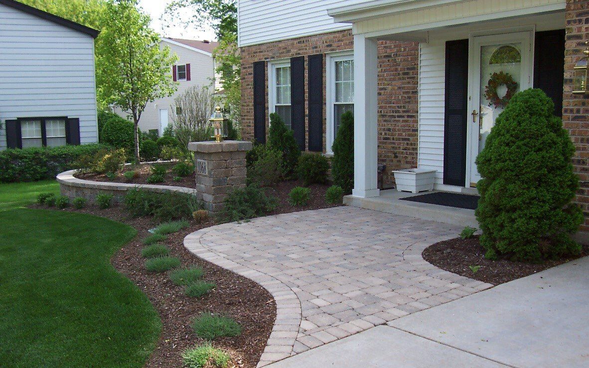 A brick house with a walkway leading to the front door