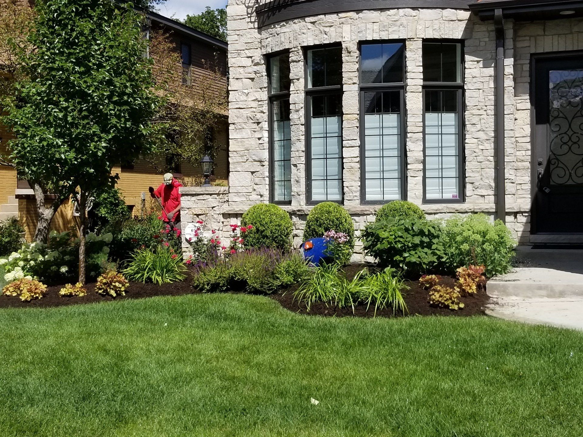 A large brick house with a lush green lawn in front of it.