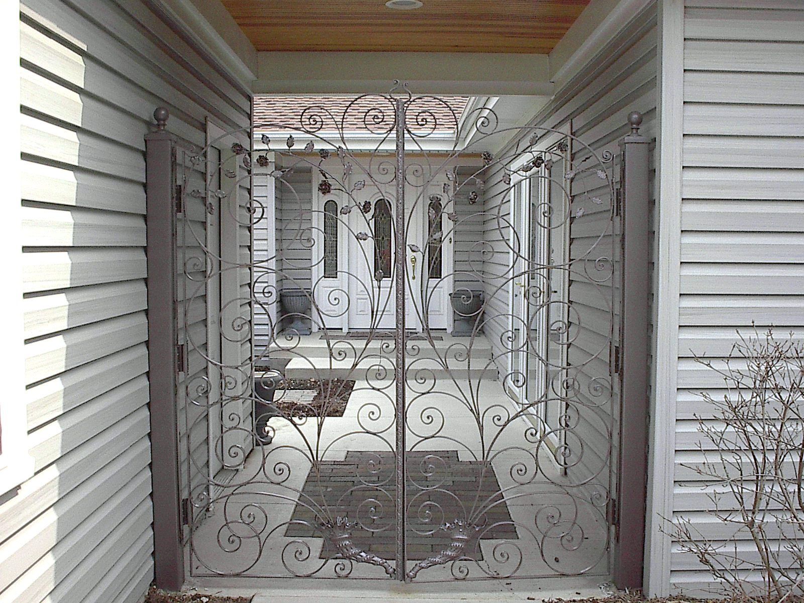 A white house with a wrought iron gate in front of it