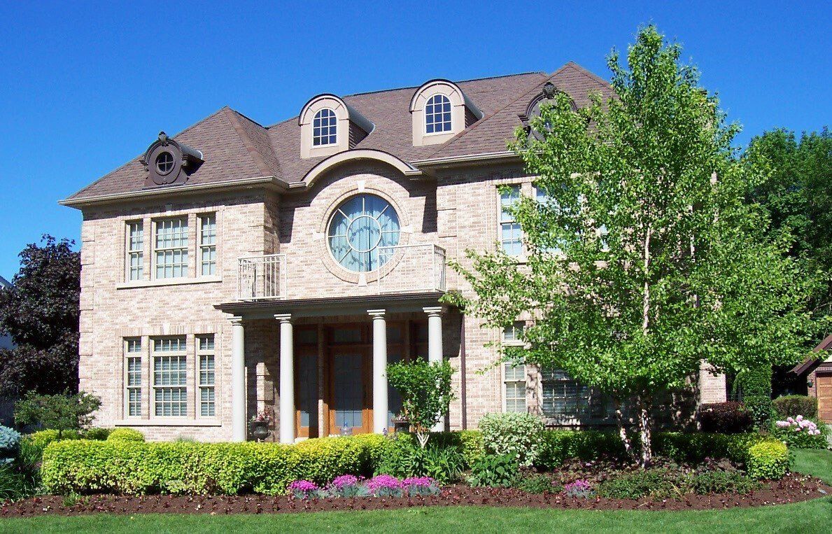 A large brick house with a clock on the front of it