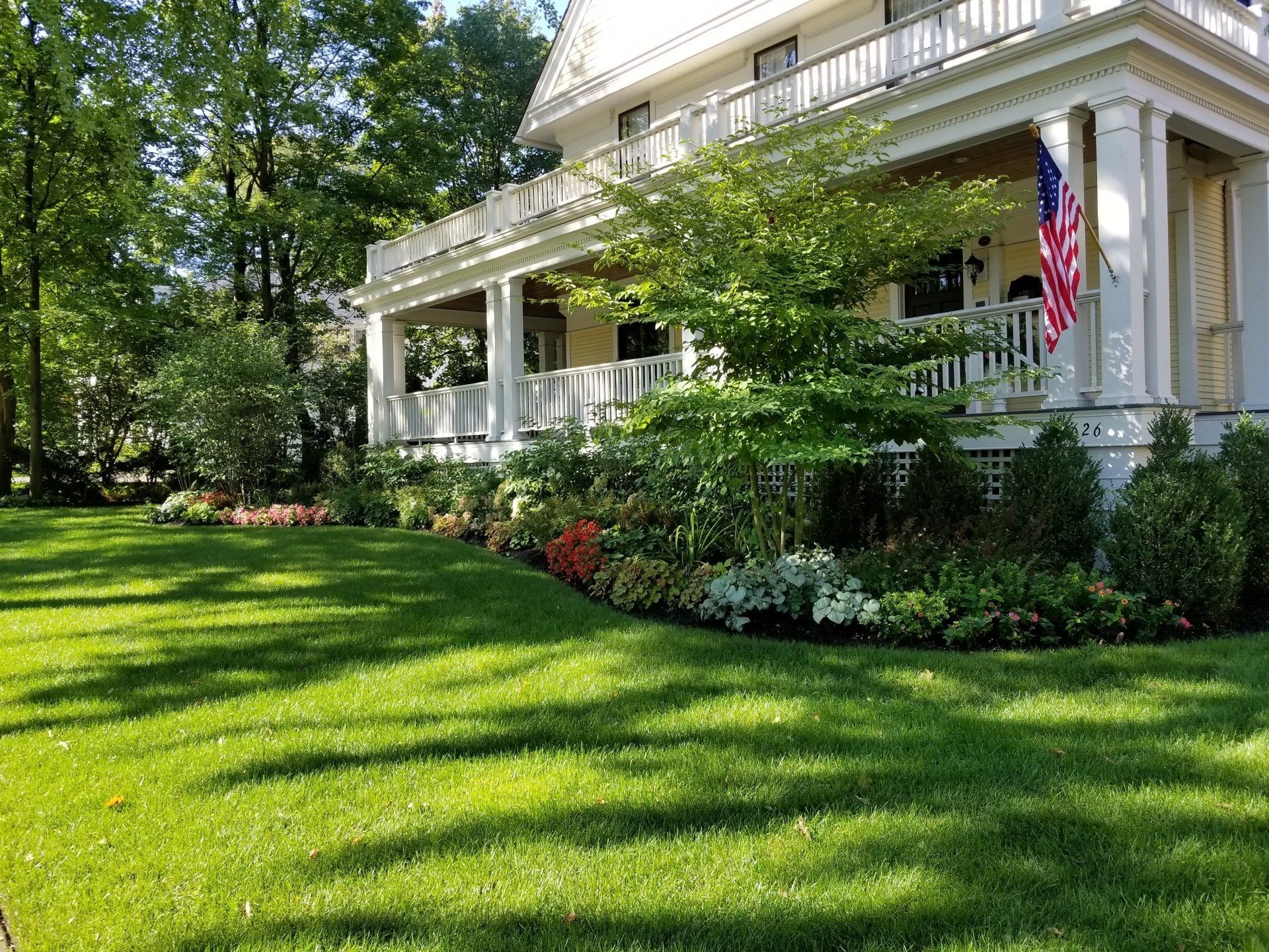 A large white house with a large lawn in front of it.