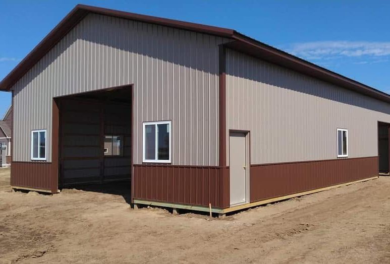 A large brown and tan metal building with a large garage door.