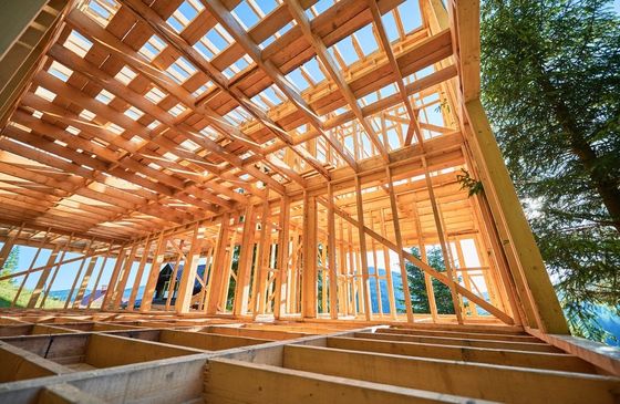 Looking up at the ceiling of a wooden house under construction.