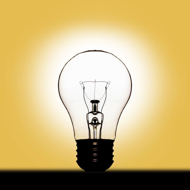 A light bulb is lit up on a yellow background