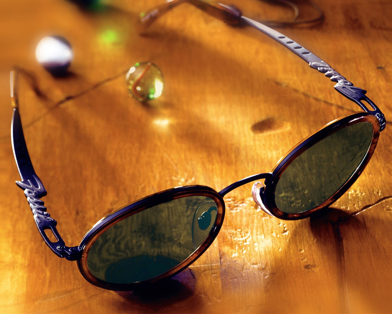 Three bracelets are sitting on a wooden table.
