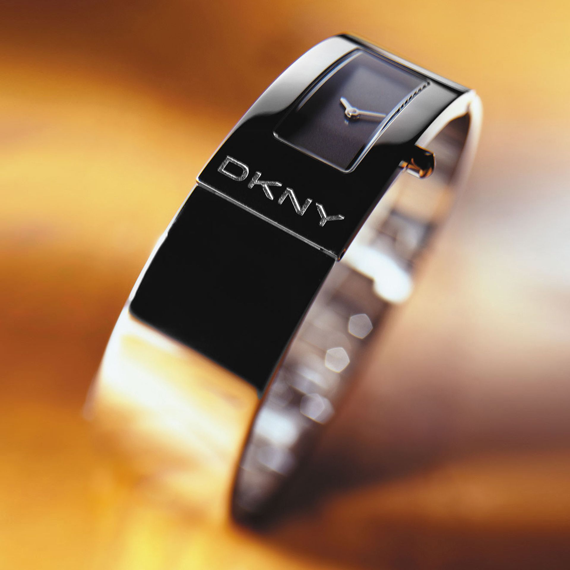 DKNY black and silver bangle watch with a square face.