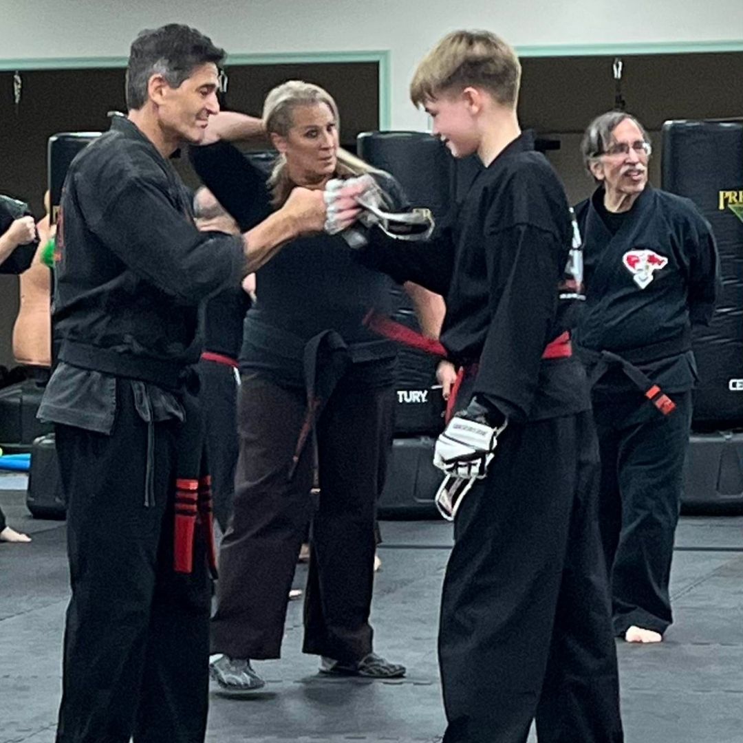 A group of men are practicing karate in a gym.
