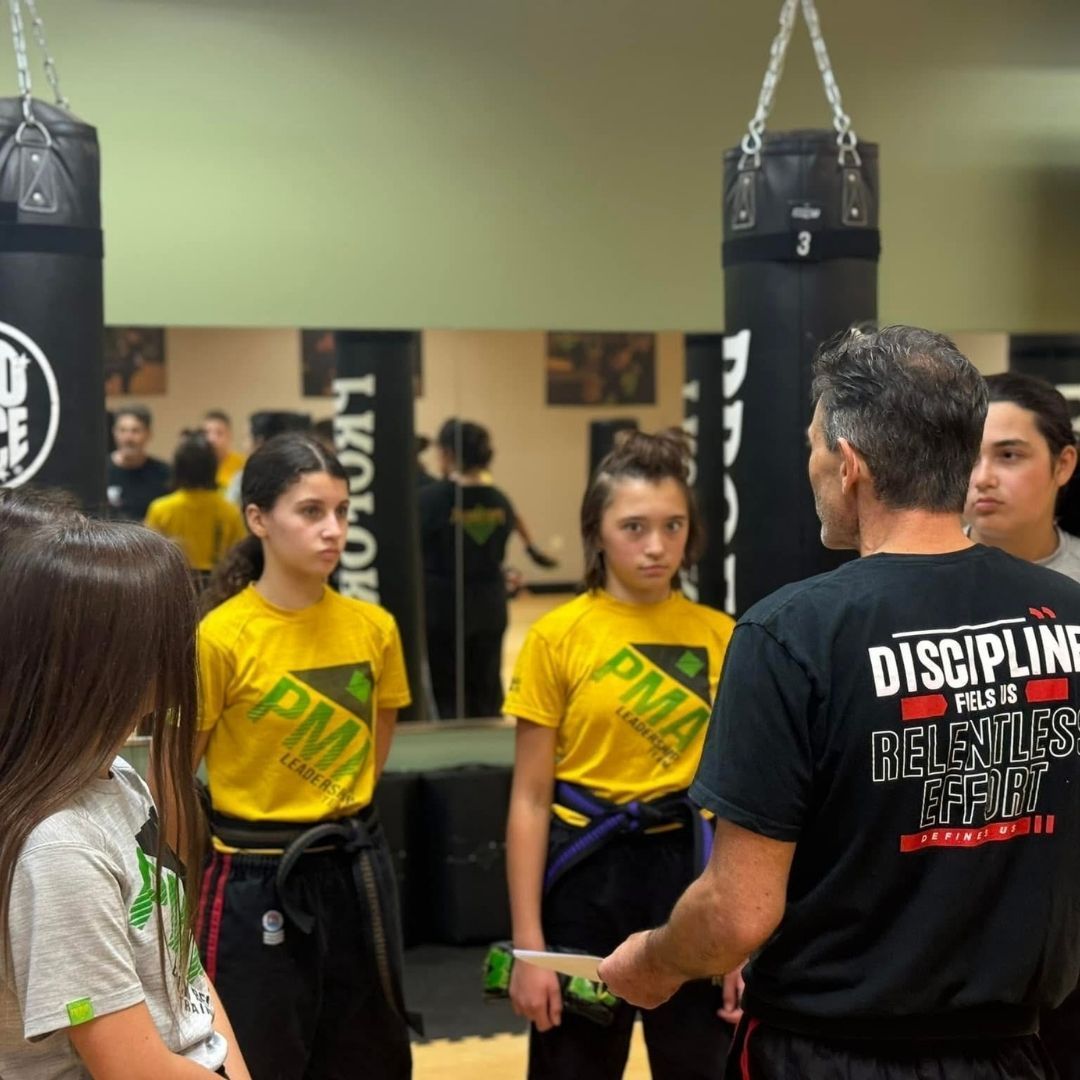 A group of men are practicing karate in a gym.
