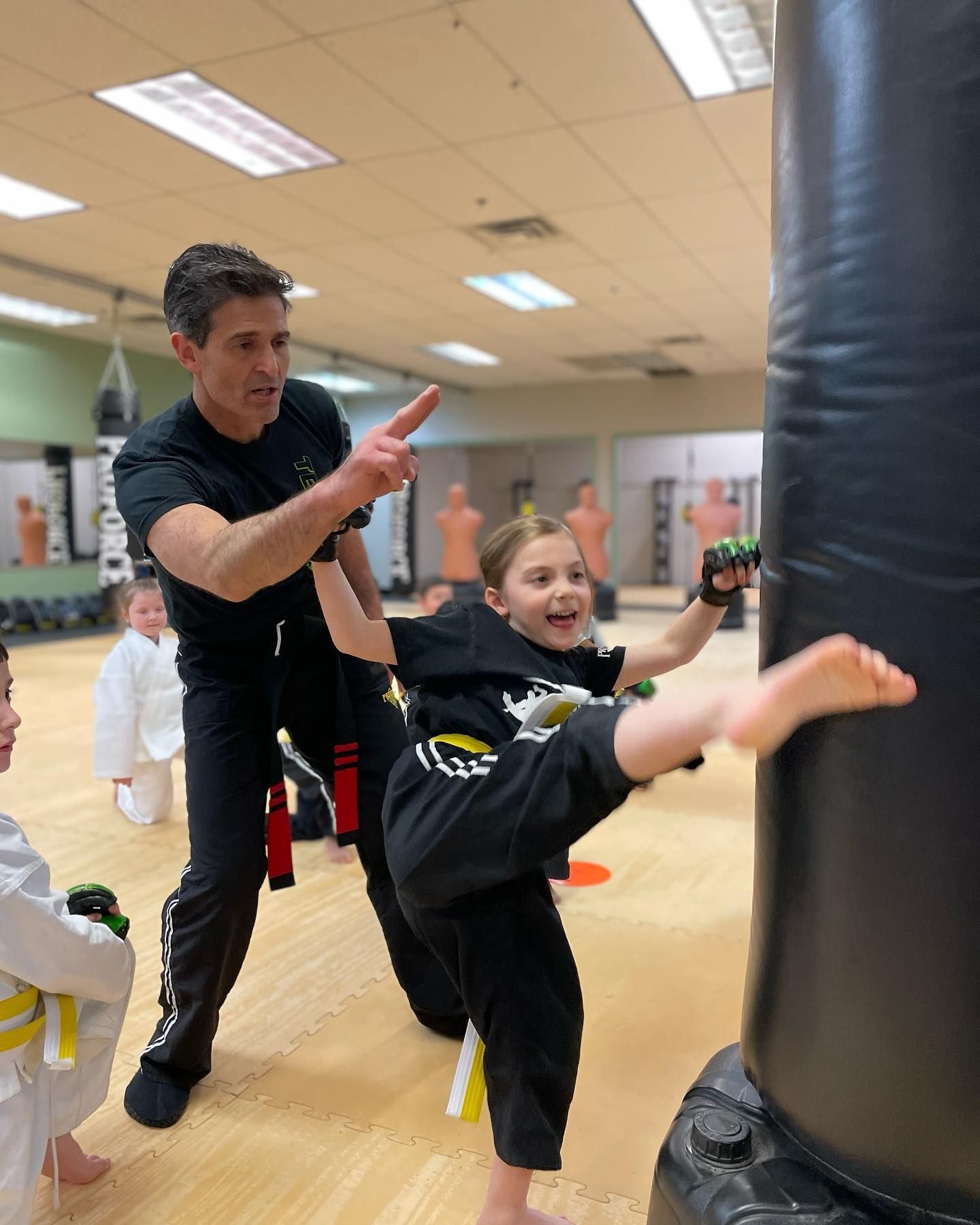 instructor teaching girl how to kick