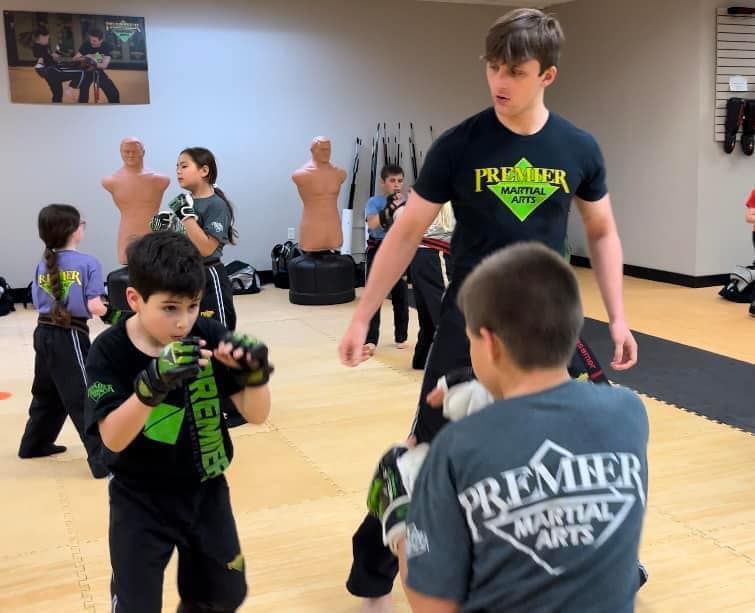 A boy wearing a premier martial arts shirt