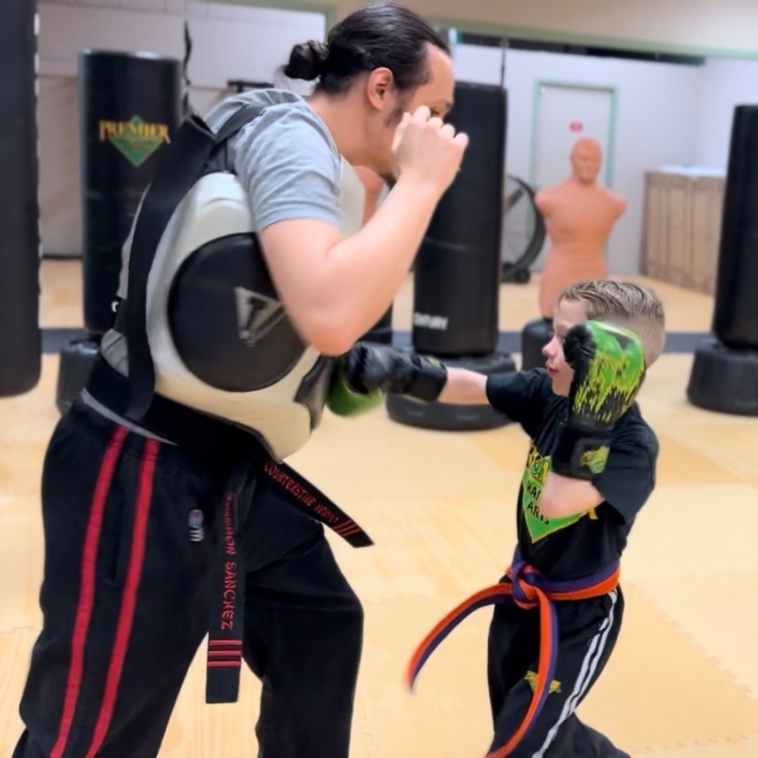 A boy and a girl are practicing taekwondo together.