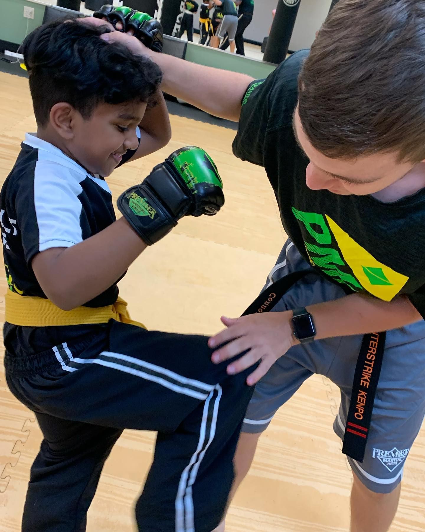 A group of young children in karate uniforms are posing for a picture.
