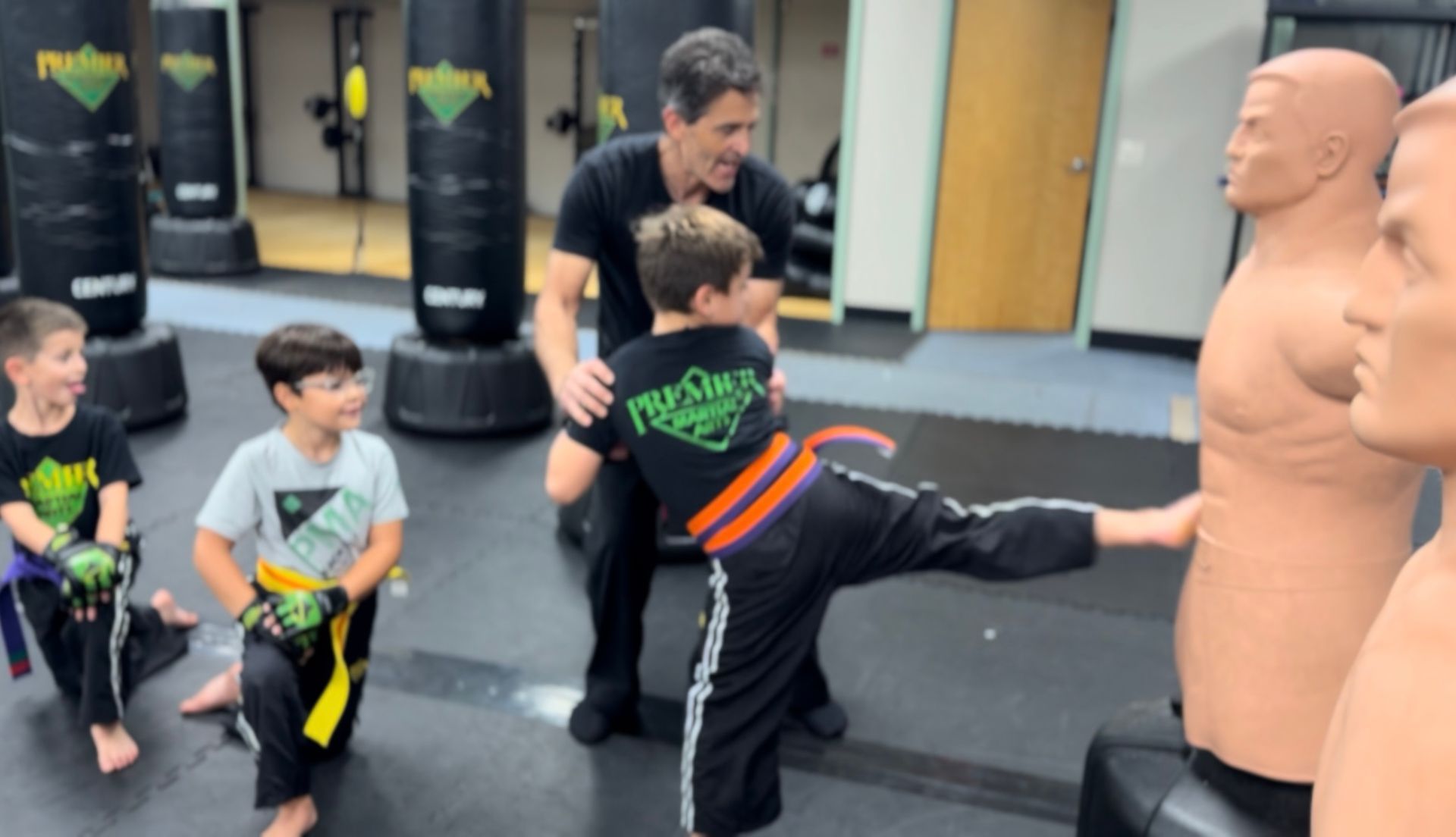 A group of young boys are kneeling on the floor holding toys.
