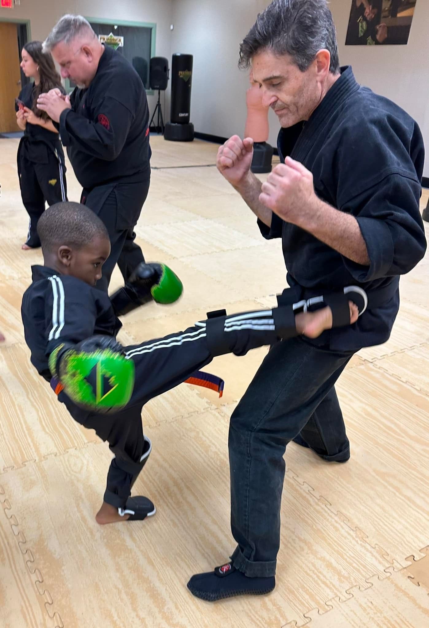 A man and a woman are practicing karate in a gym.