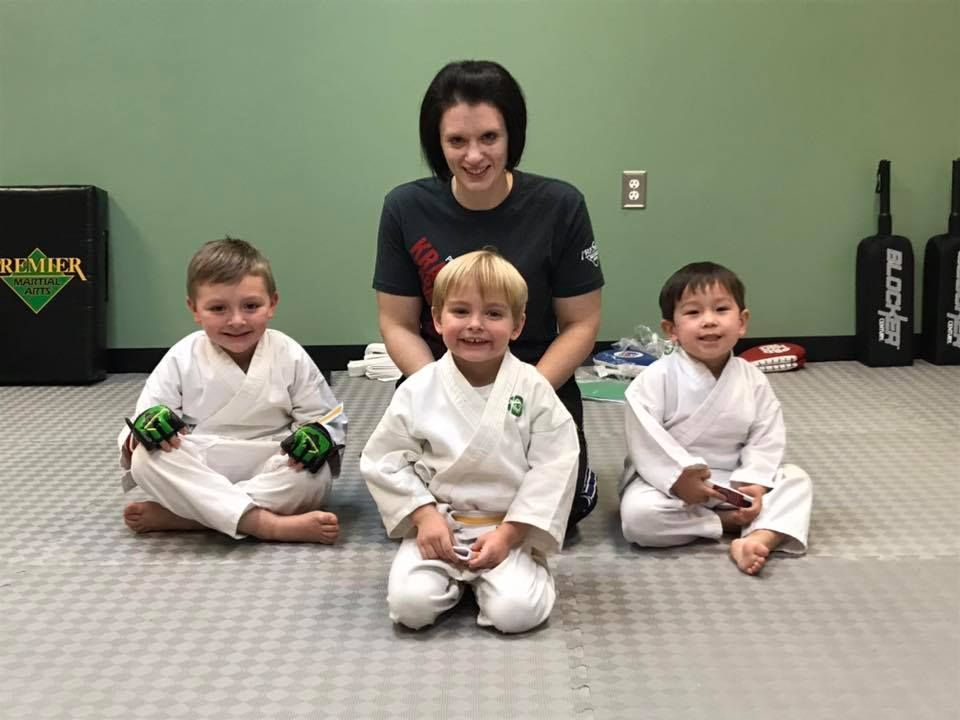 A group of young girls are practicing karate in a gym.