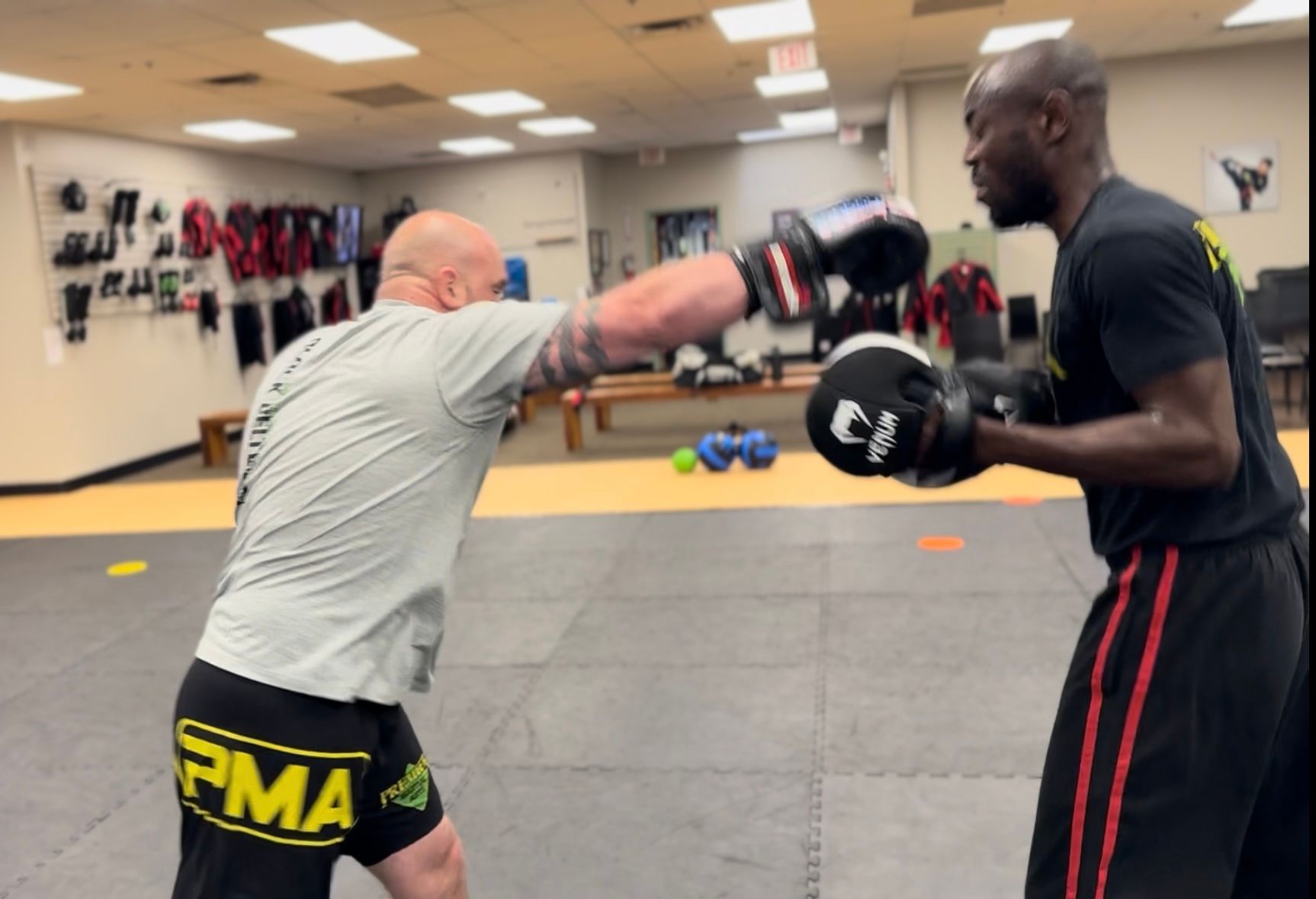 A group of men are practicing martial arts in a gym.