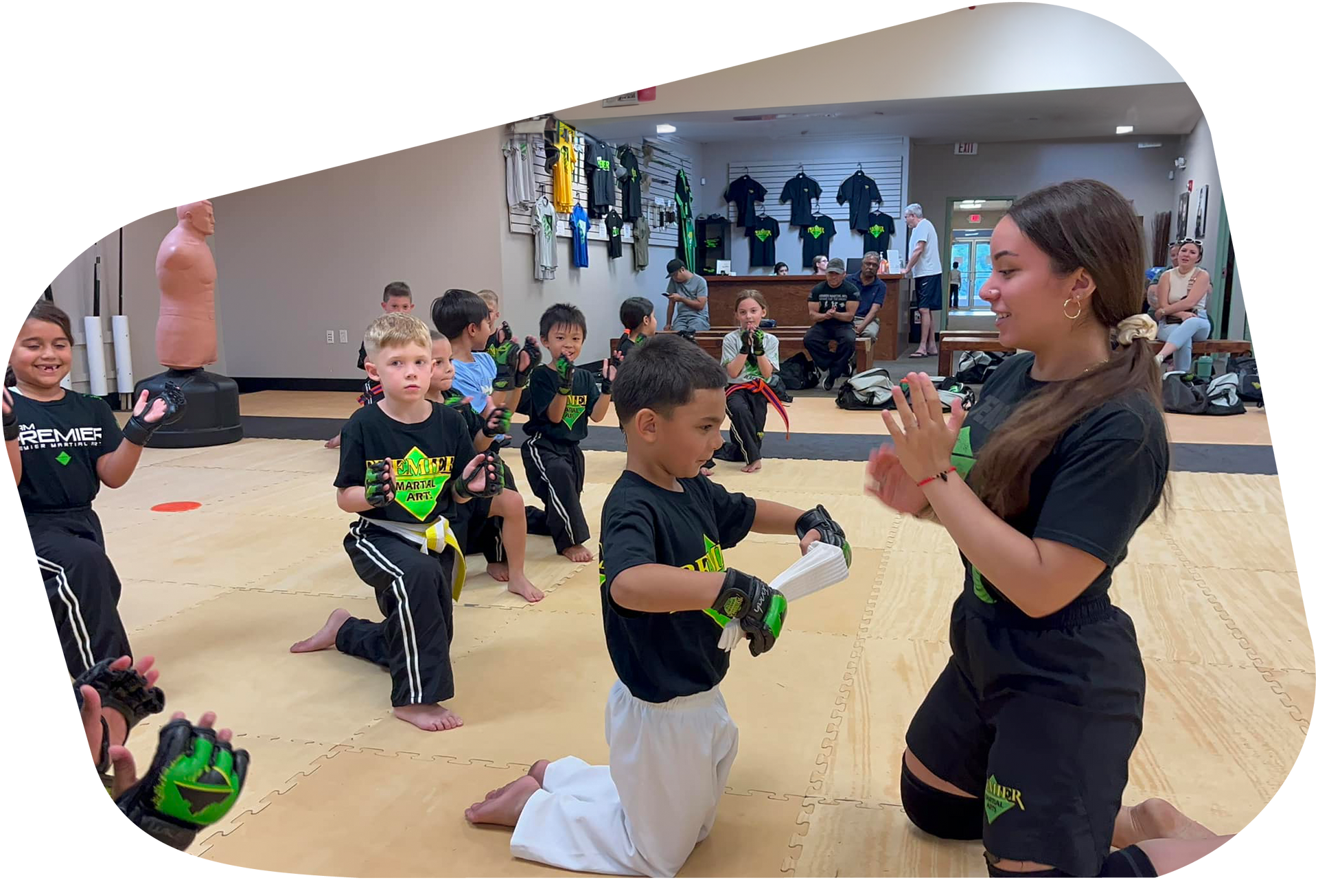 A group of young children are practicing martial arts in a gym.