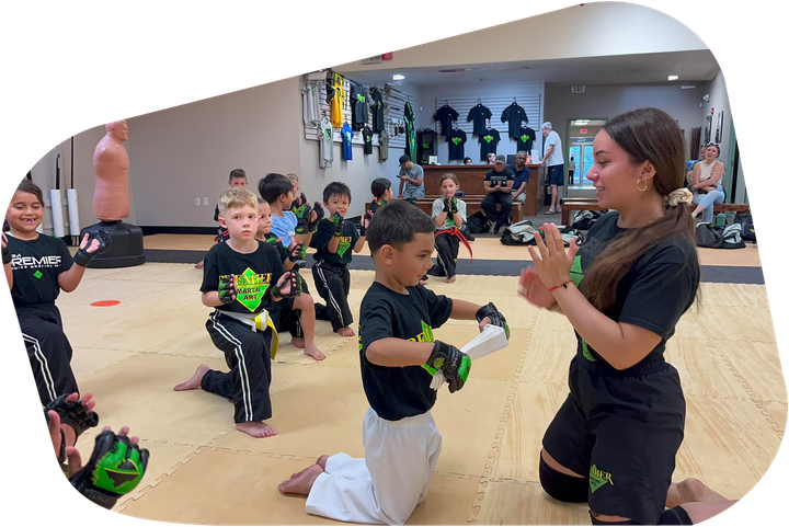 A group of young children are practicing martial arts in a gym.