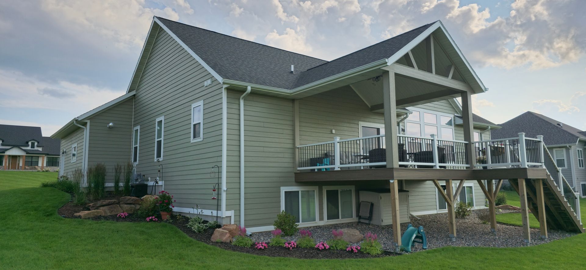 A large house with a large deck in the backyard.