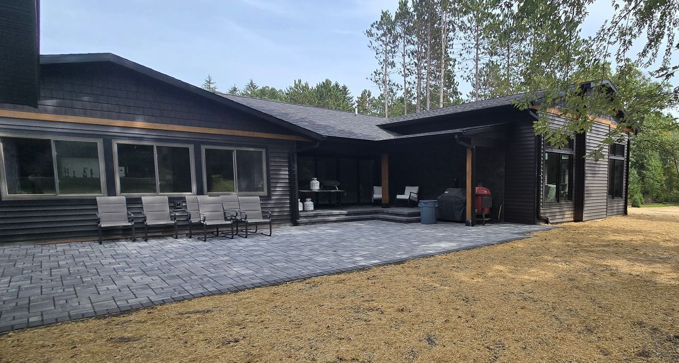 A large house with a patio and chairs in front of it.