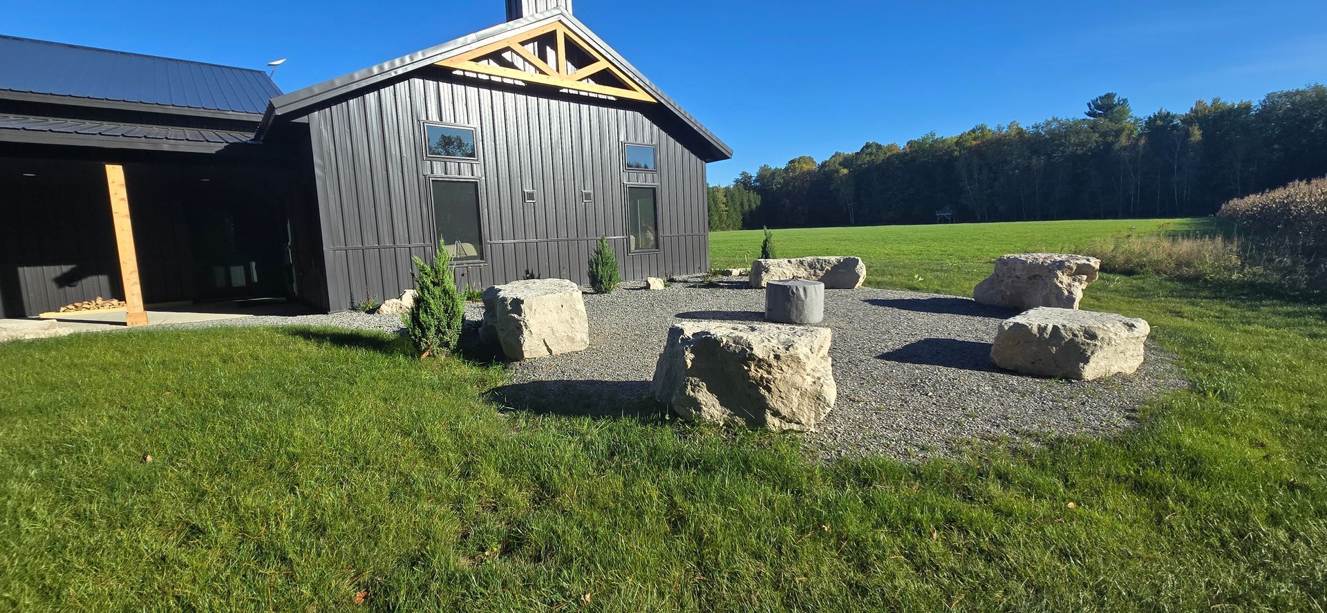 There is a fire pit in the grass in front of a house.