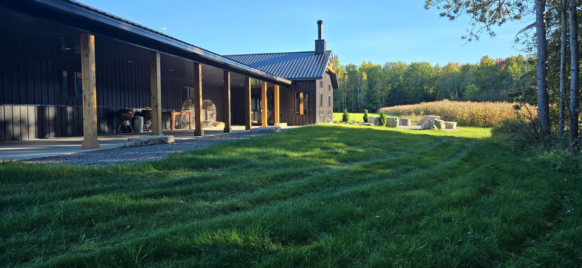 A large house with a covered porch and a large lawn in front of it.
