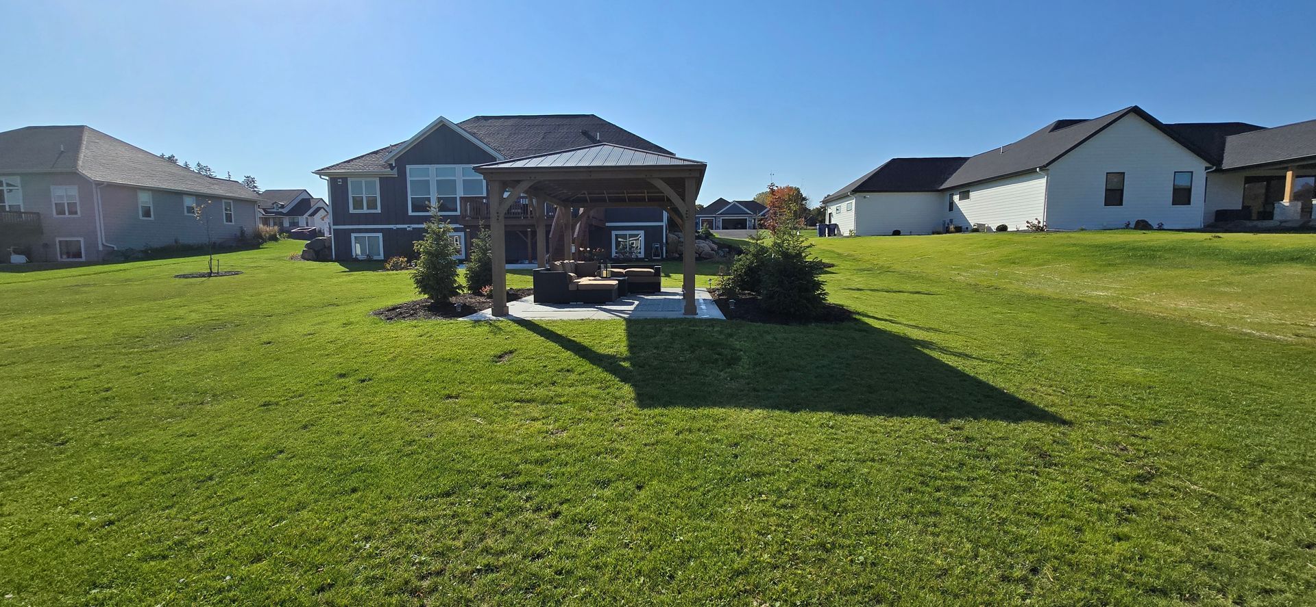 A large lawn in front of a house in a residential area.