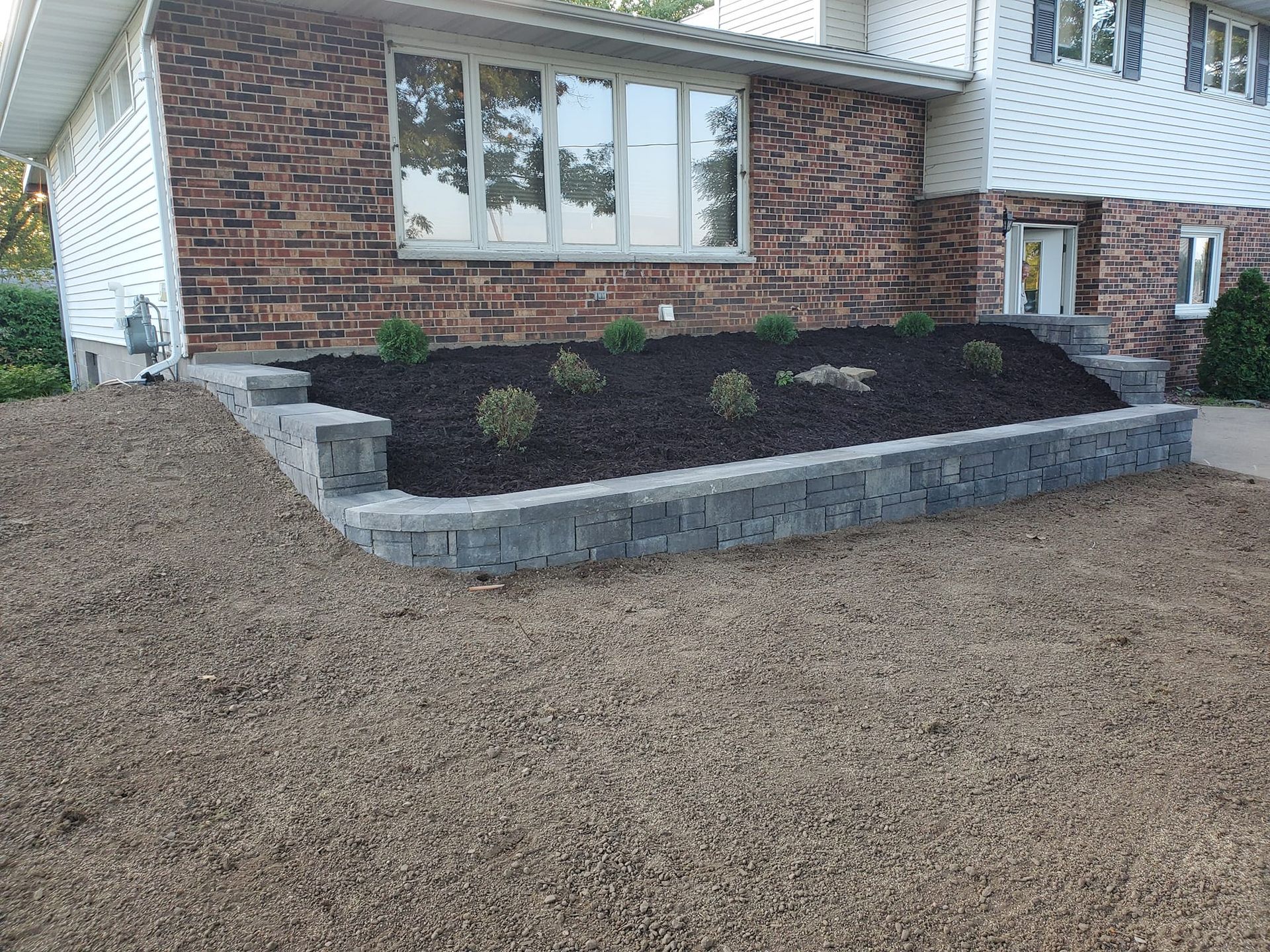 A brick house with a lush green lawn in front of it.