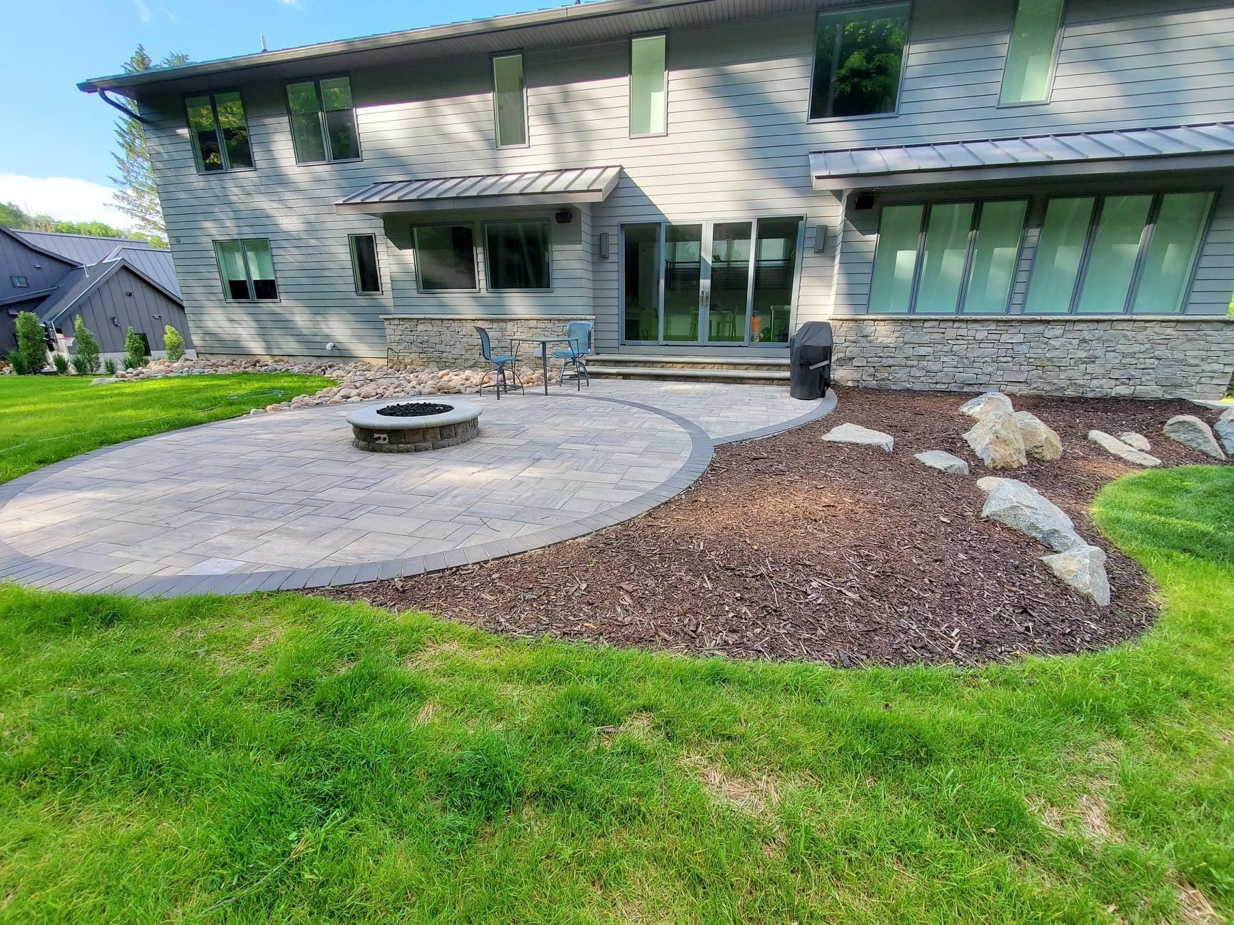 There is a fire pit in the backyard of a house.