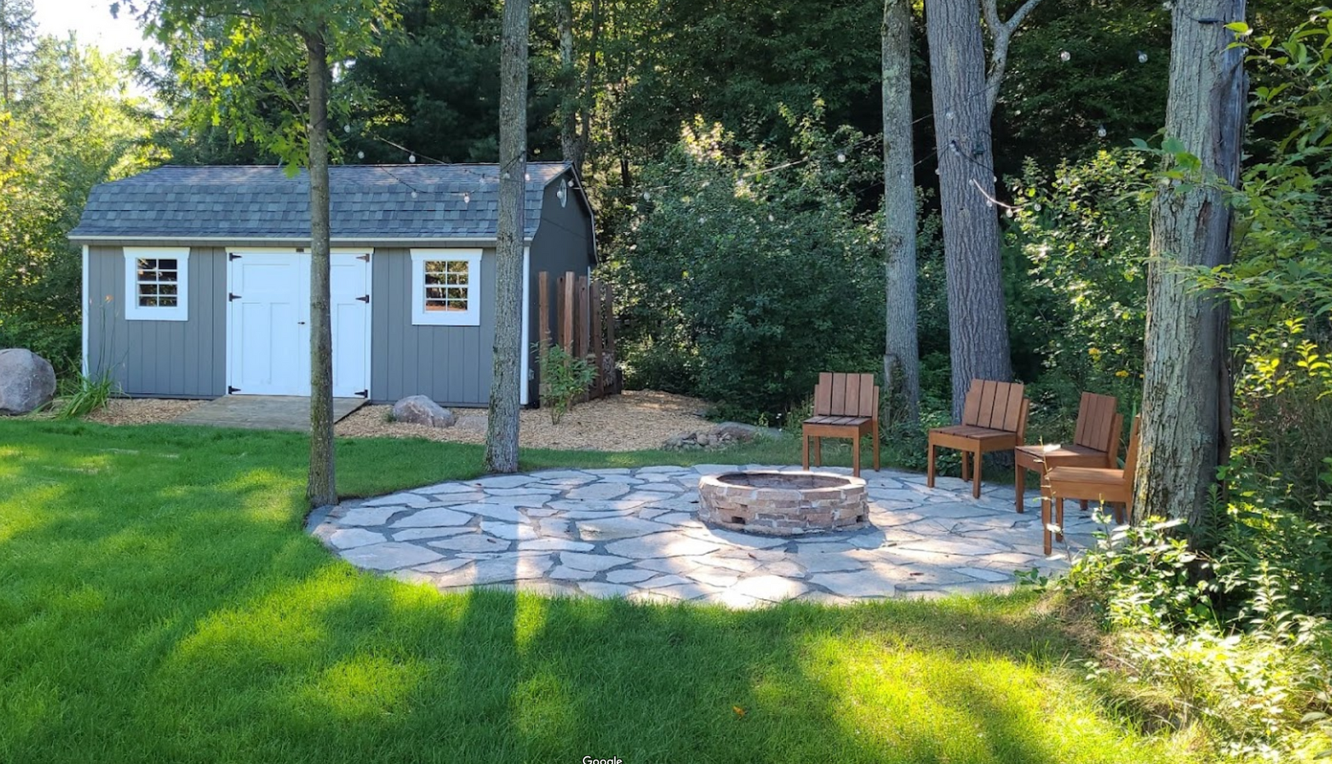 There is a fire pit in the middle of the yard in front of a shed in Wausau, Wisconsin