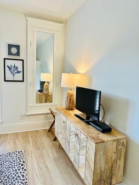 A living room with a wooden entertainment center and a flat screen tv.