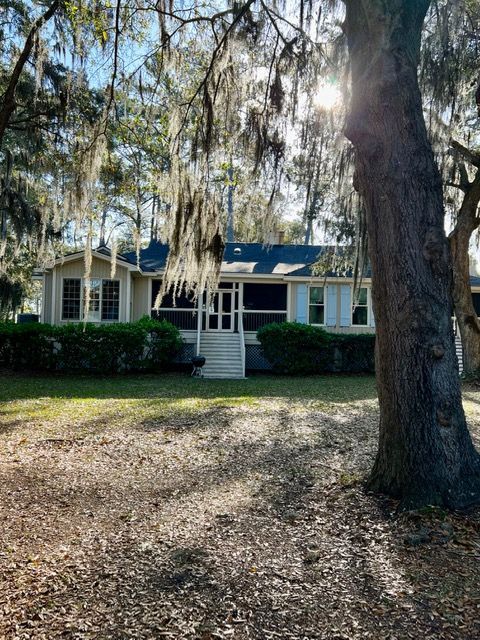 A house with spanish moss hanging from the trees in front of it