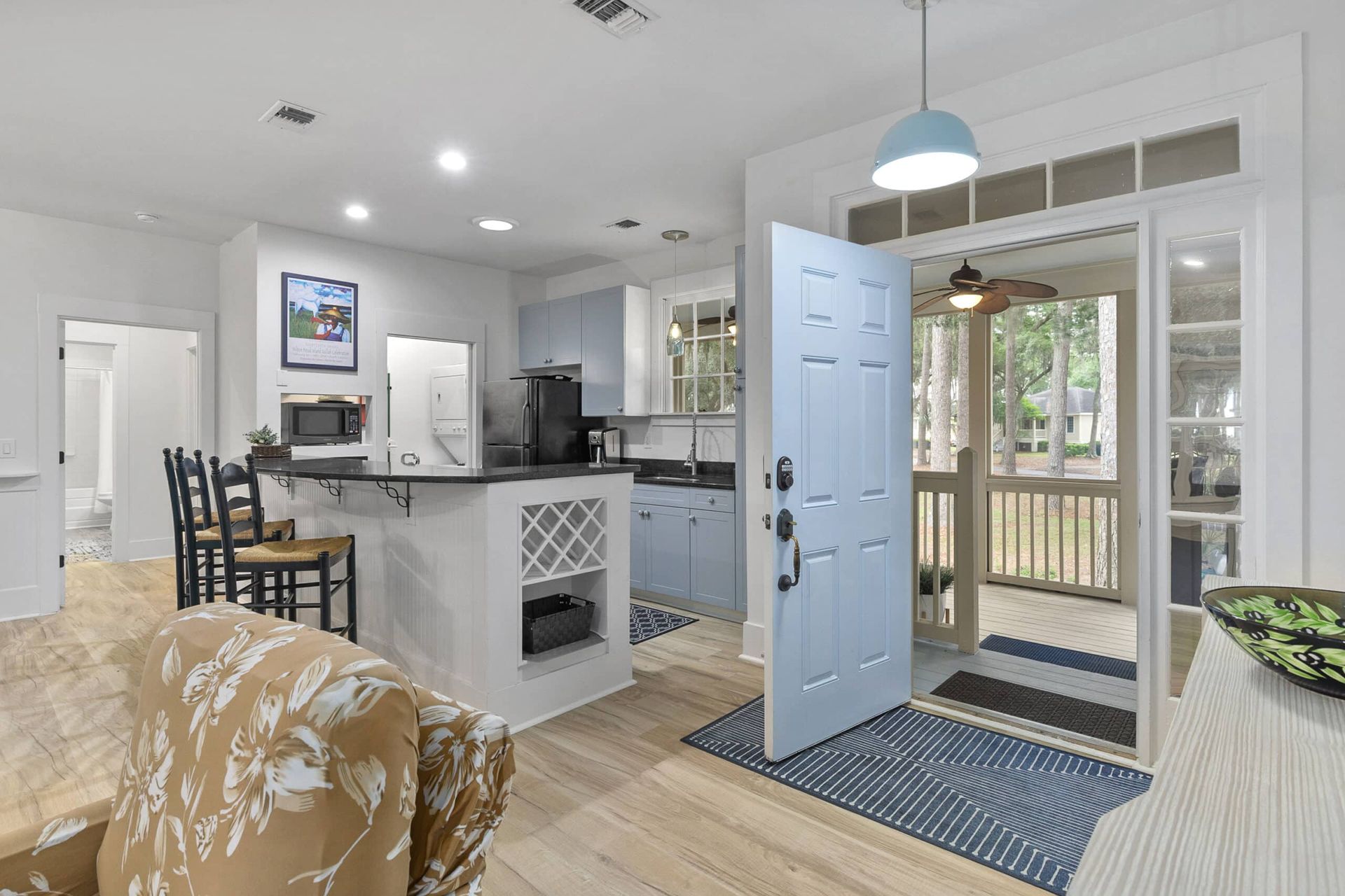 A living room with a blue door leading to a kitchen.