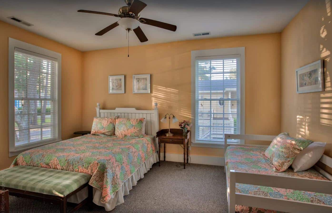 A bedroom with a bed , bunk bed and ceiling fan.